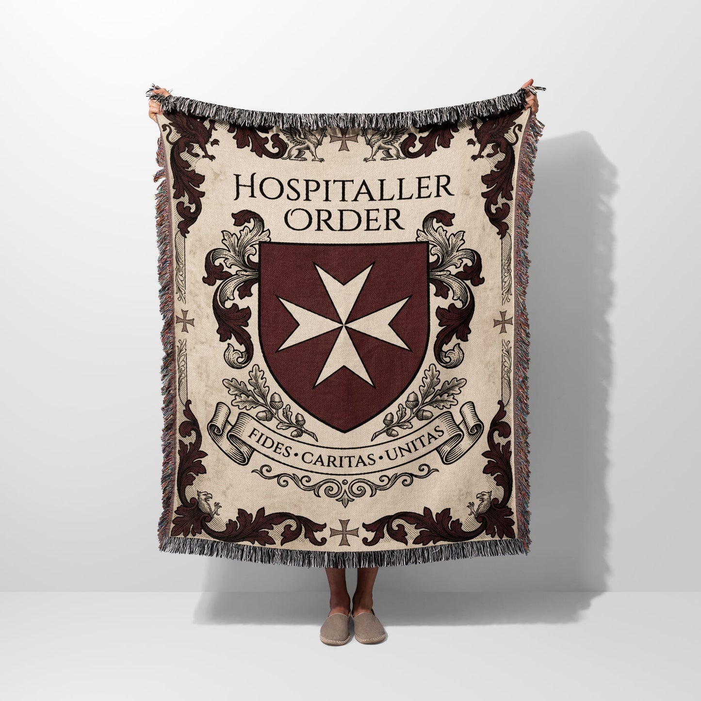 Hospitalier Order crest with Maltese cross and banner on a woven blanket.