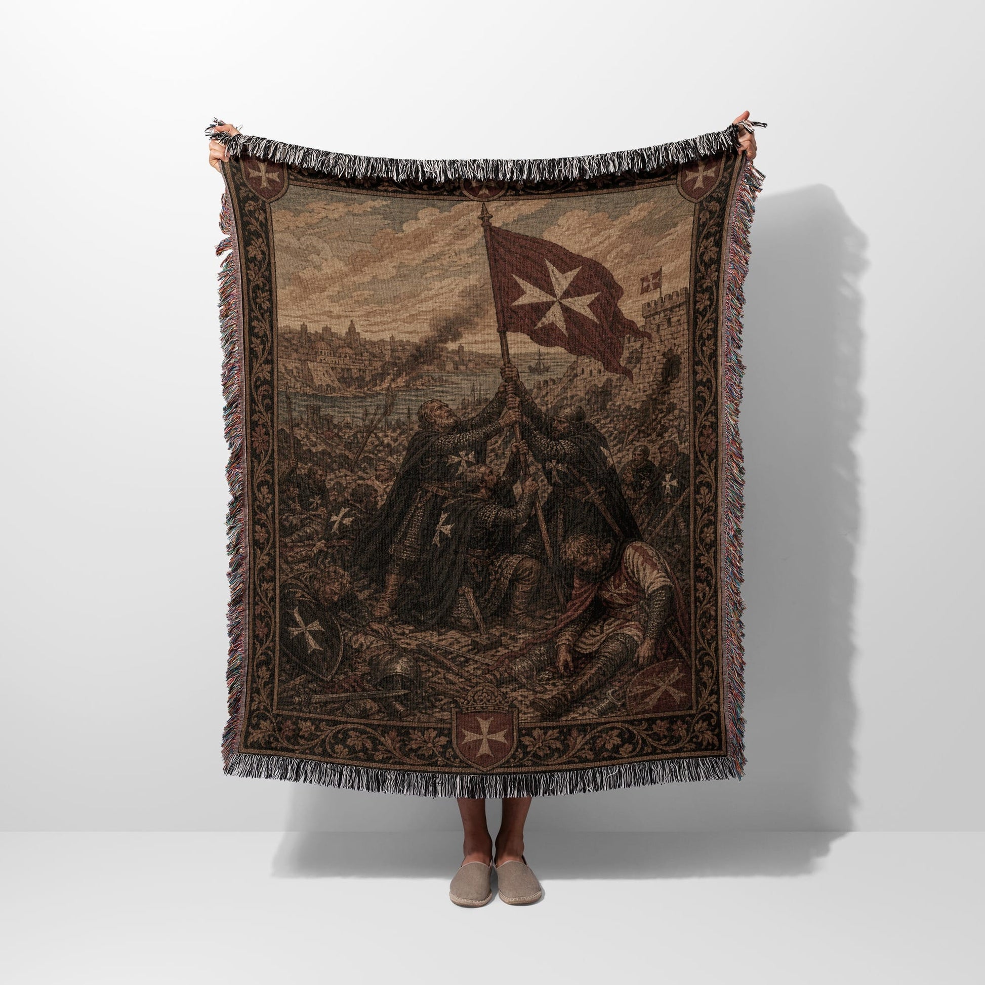 Tapestry blanket depicting knights in battle, holding a Maltese cross flag.