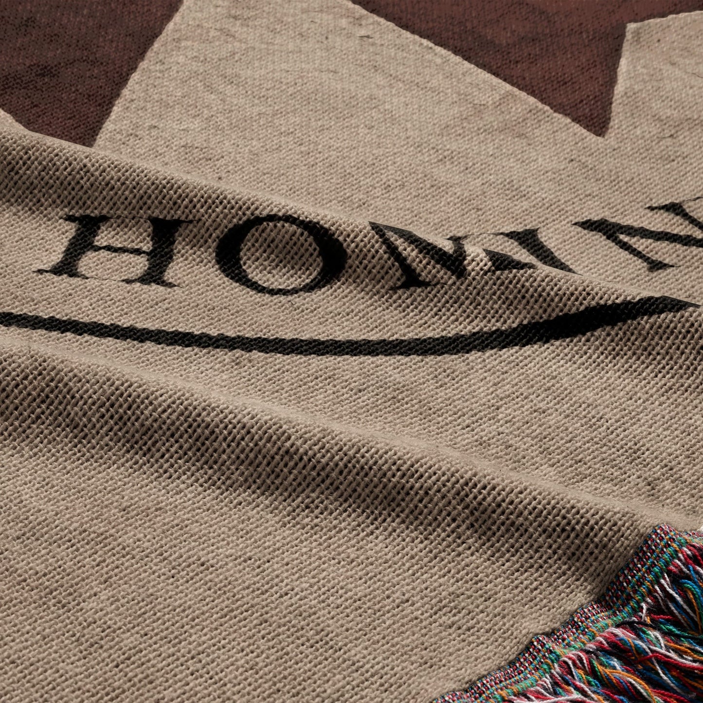 Woven throw with black lettering "HONDA" and striped fringe.