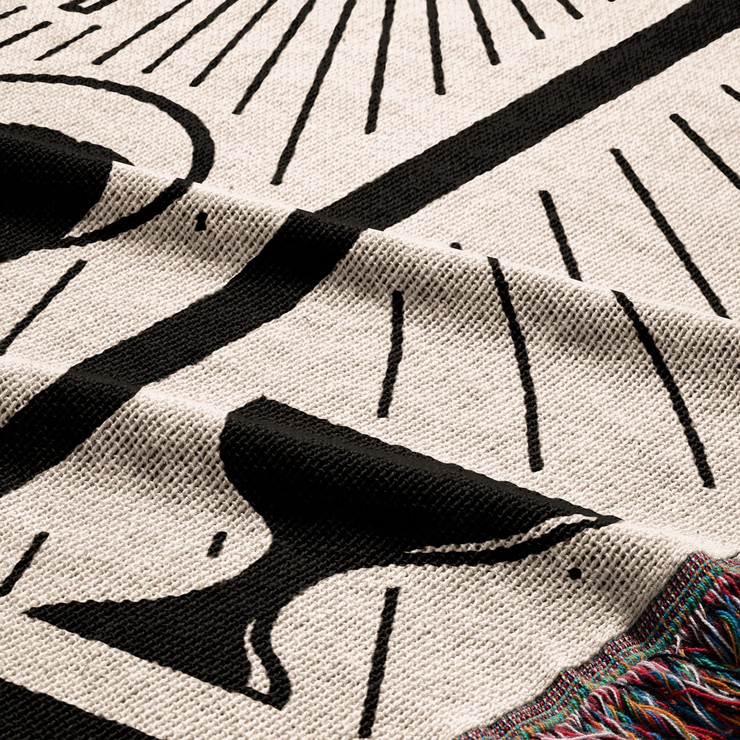 Black and white celestial pattern on a cream knit blanket with fringed edge.
