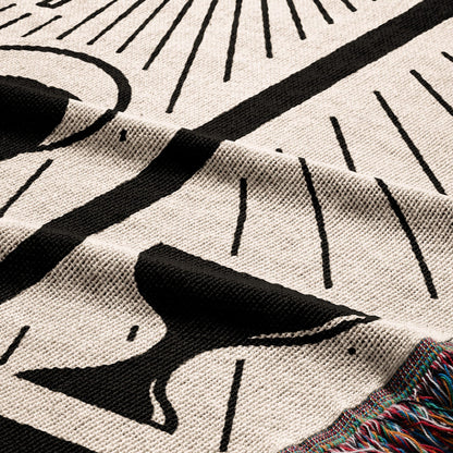 Black and white celestial pattern on a cream knit blanket with fringed edge.