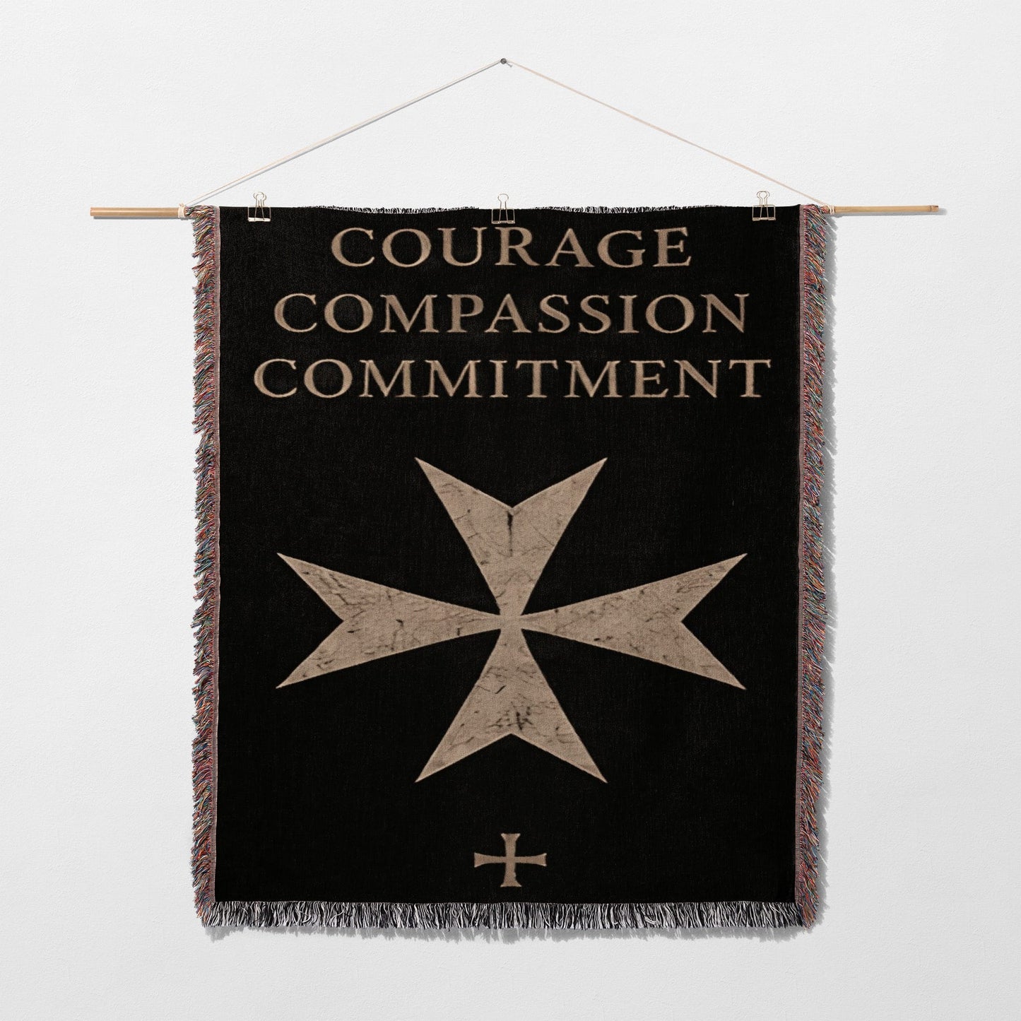 Black banner with gold text "COURAGE COMPASSION COMMITMENT" and a maltese cross.