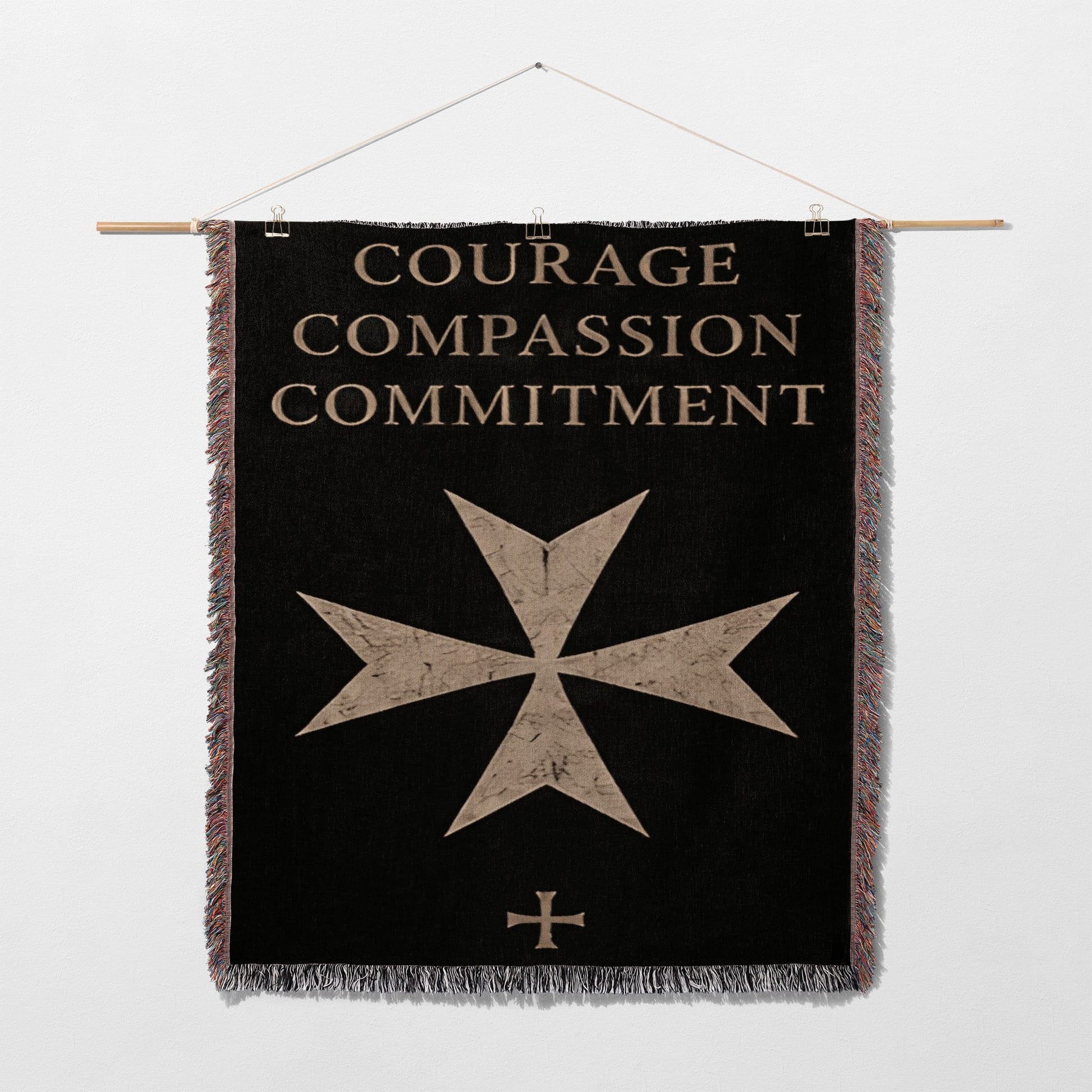 Black banner with gold text "COURAGE COMPASSION COMMITMENT" and a maltese cross.