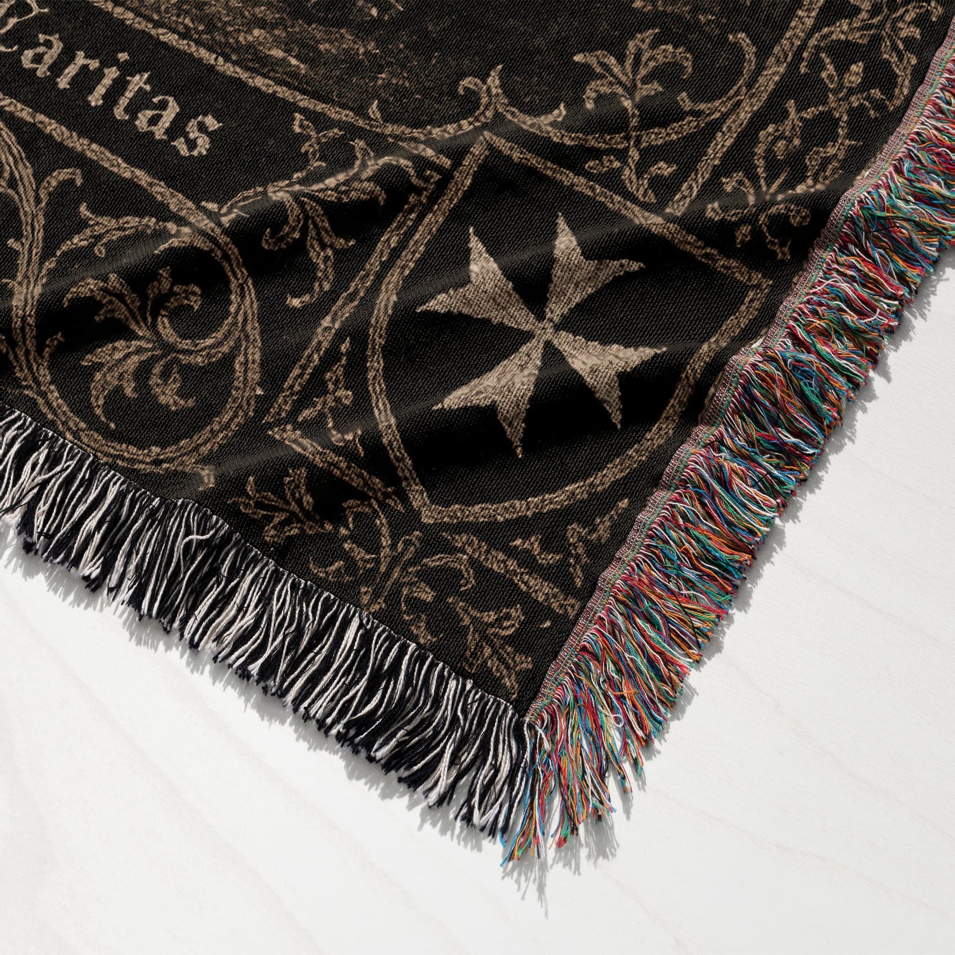 Black blanket with Maltese cross and ornate scrollwork, fringed edge.