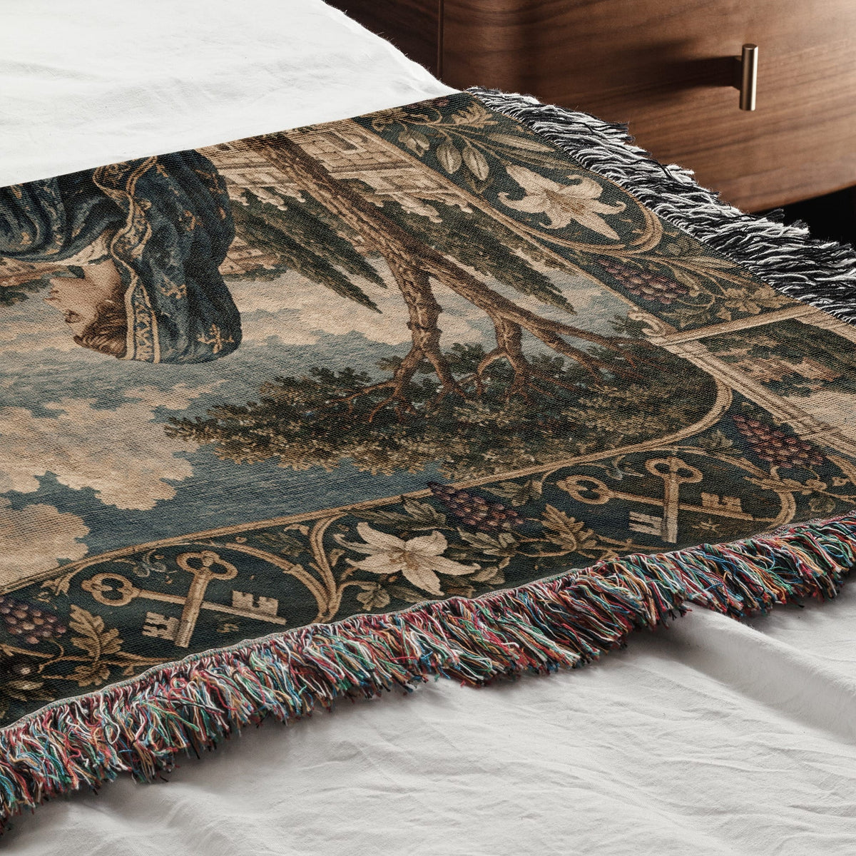 Woven throw blanket featuring a classic tapestry design with figures, trees, and decorative fringe.