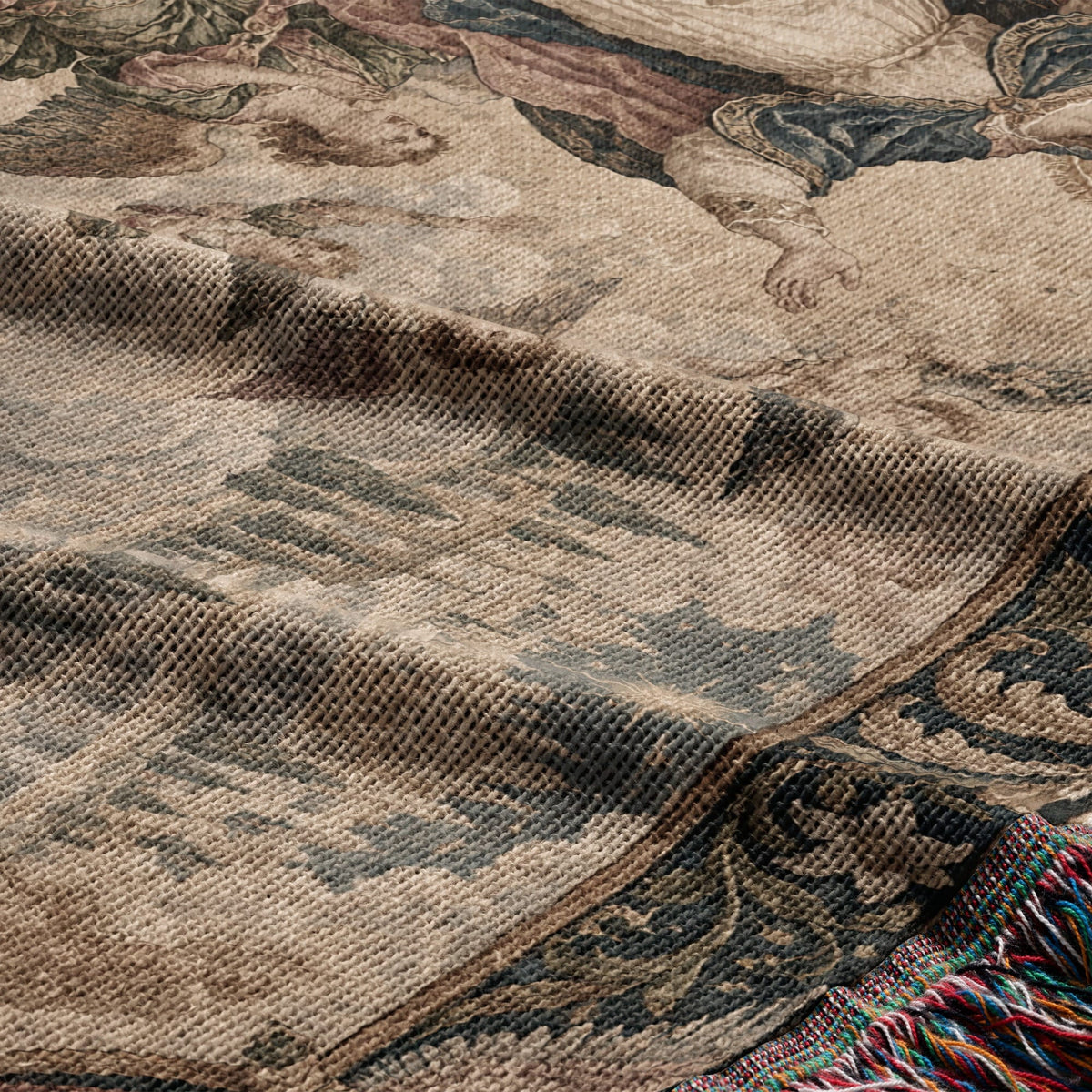 A folded woven tapestry featuring a historical illustration in muted earth tones with a fringed edge.
