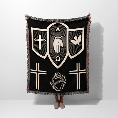 Black tapestry blanket with religious symbols: hand, dove, crosses, and heart.