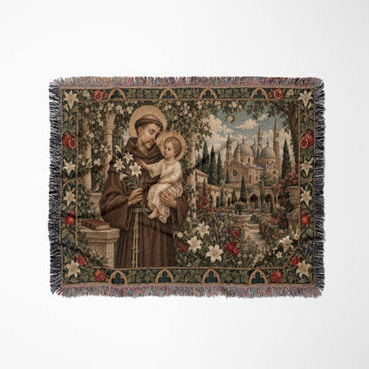 Woven tapestry throw featuring Saint Anthony holding the Christ Child amidst a garden and cathedral backdrop.