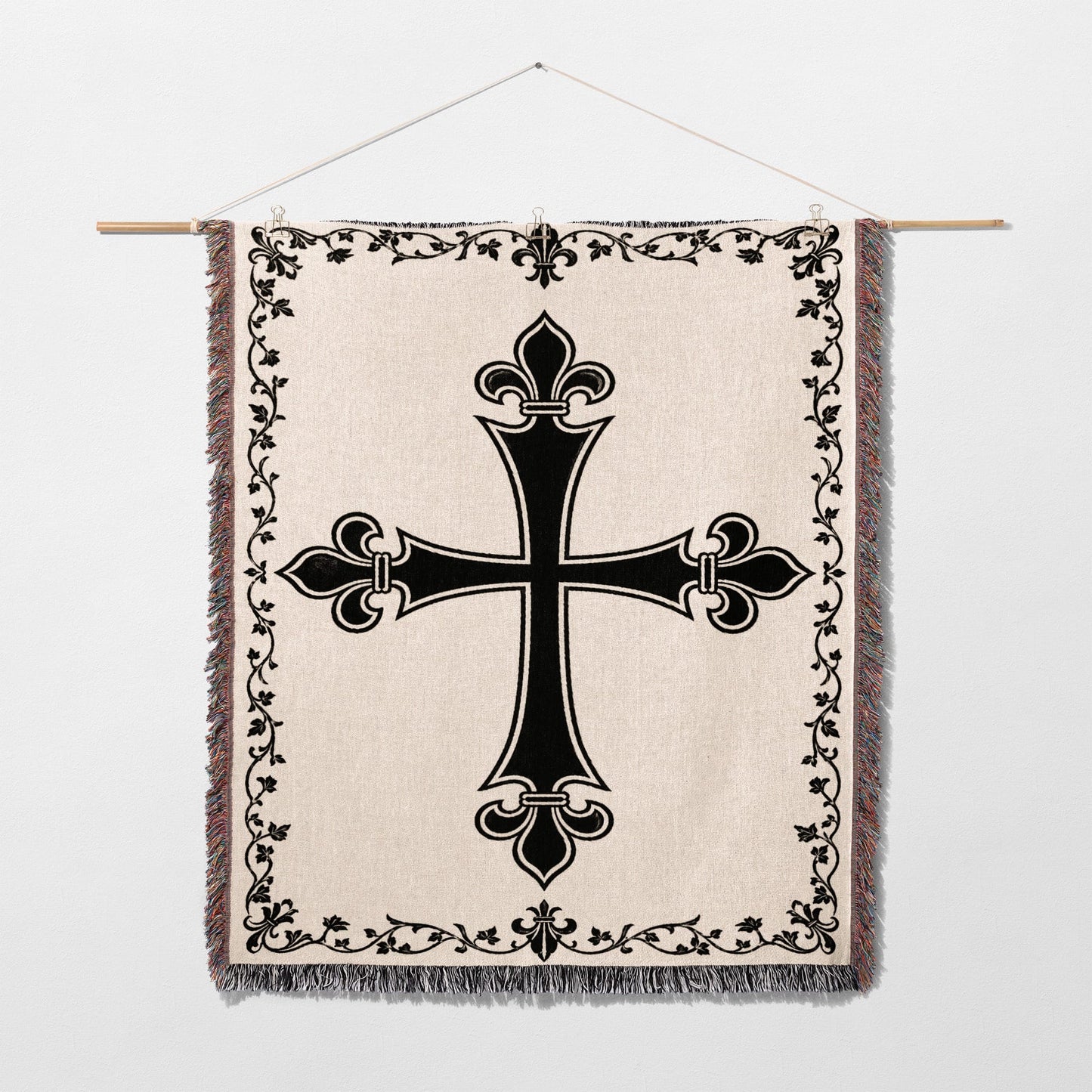 Black ornate cross on a cream woven tapestry with decorative border.