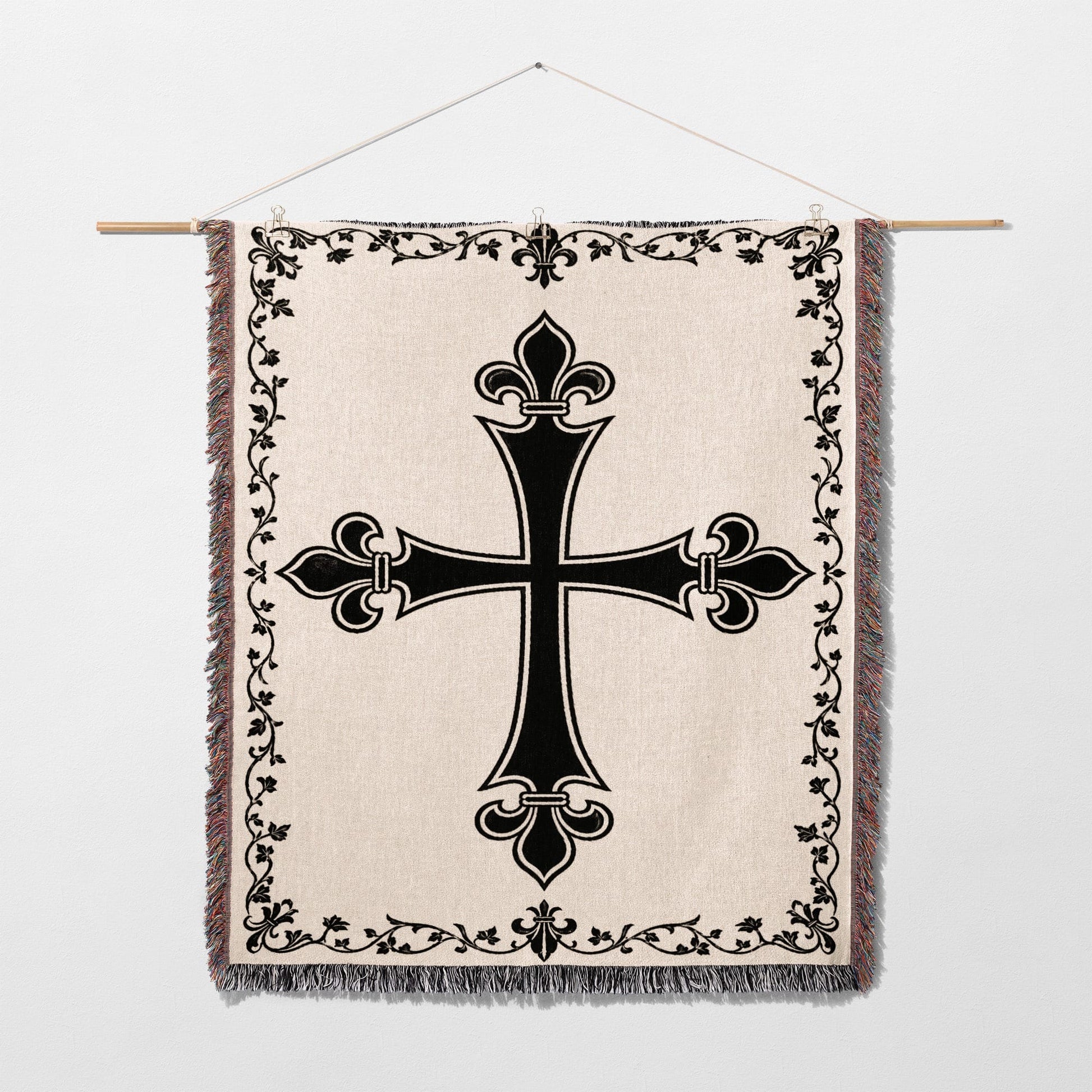 Black ornate cross on a cream woven tapestry with decorative border.