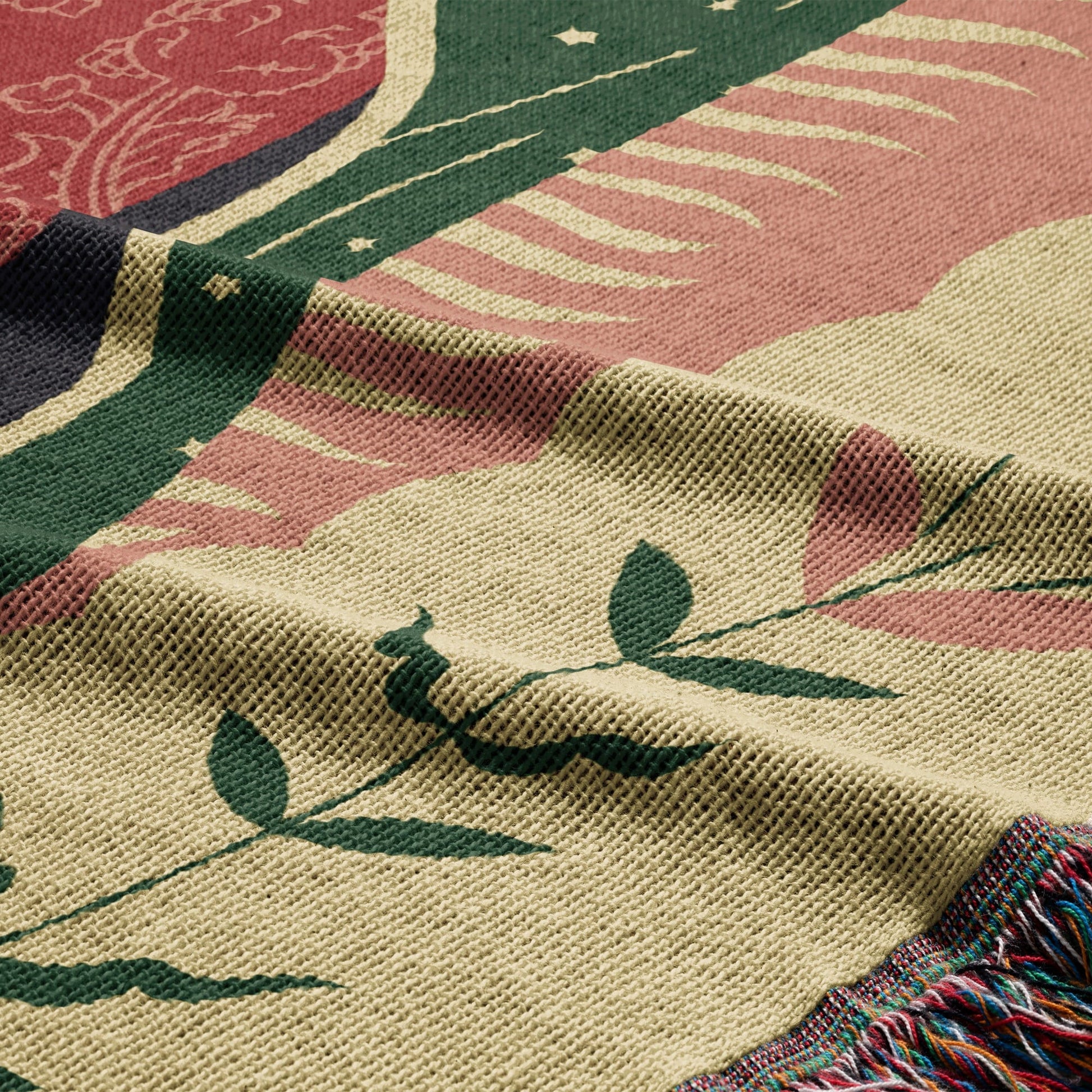 Woven blanket with floral and celestial patterns in muted colors.