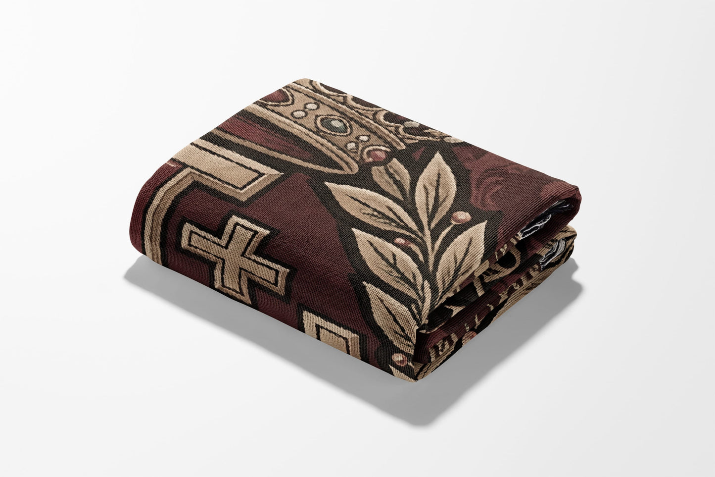 Folded textile with crown, cross, and leaf pattern on a white background.