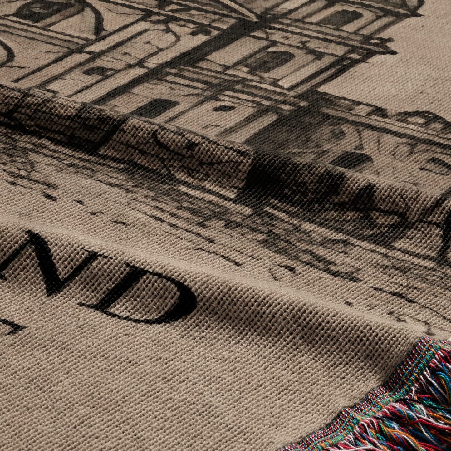 Woven throw with architectural print and colorful fringe.