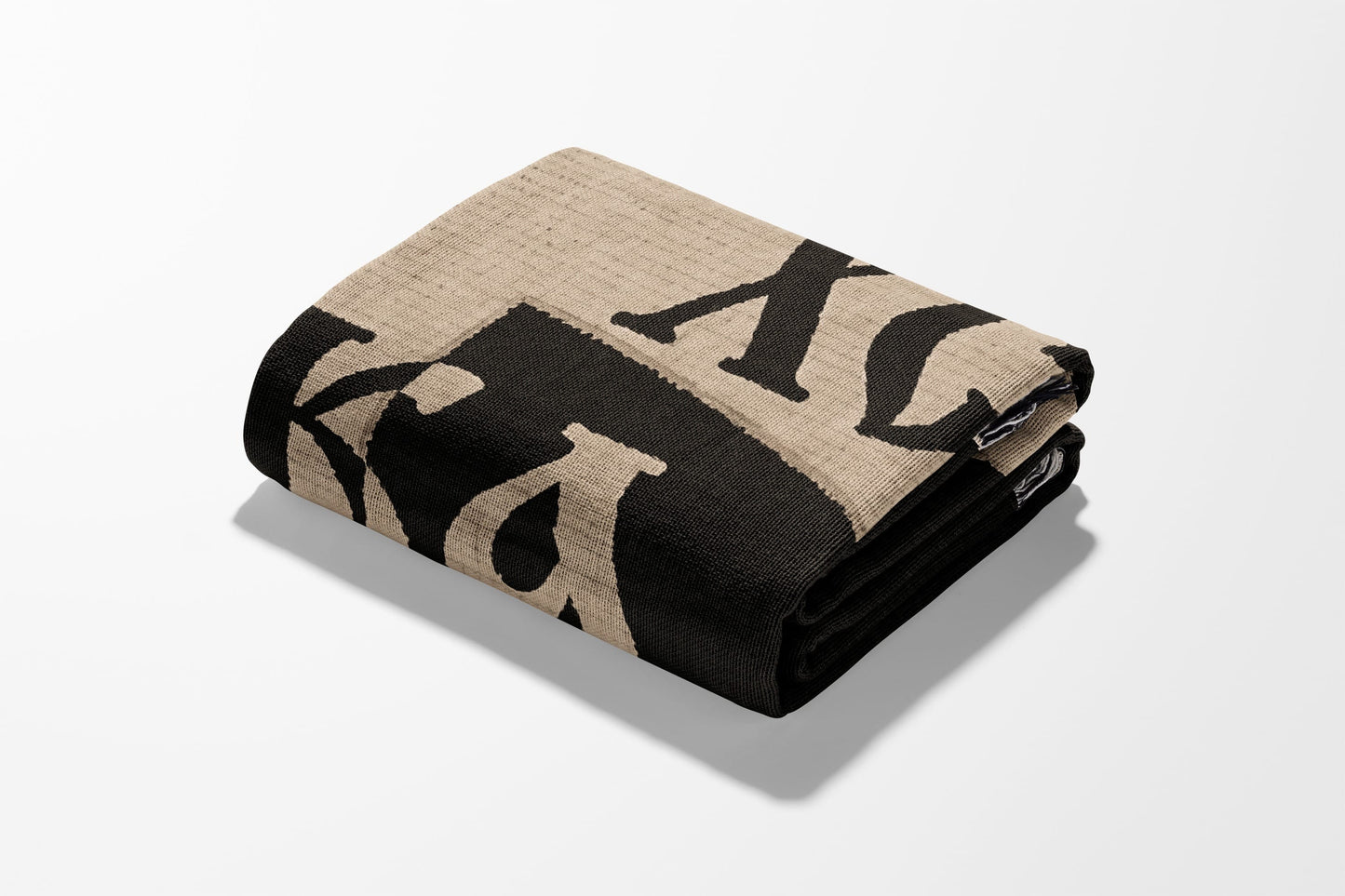 Folded blanket with large black "XX" letters on a tan background.