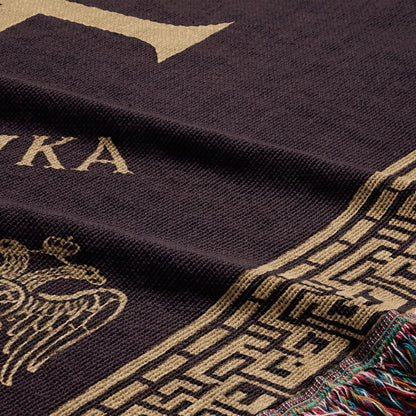 Dark brown throw blanket with gold border and crest.