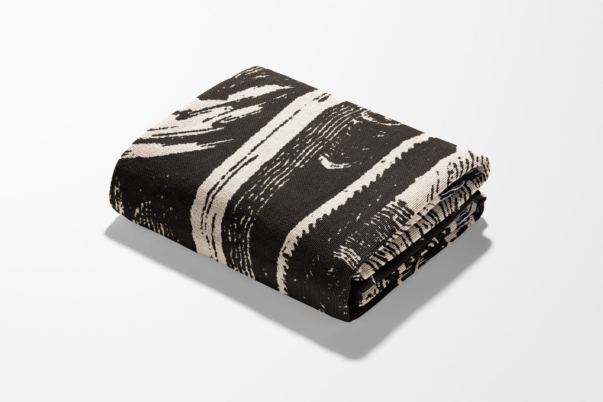 Folded blanket with abstract black and white stripe pattern.