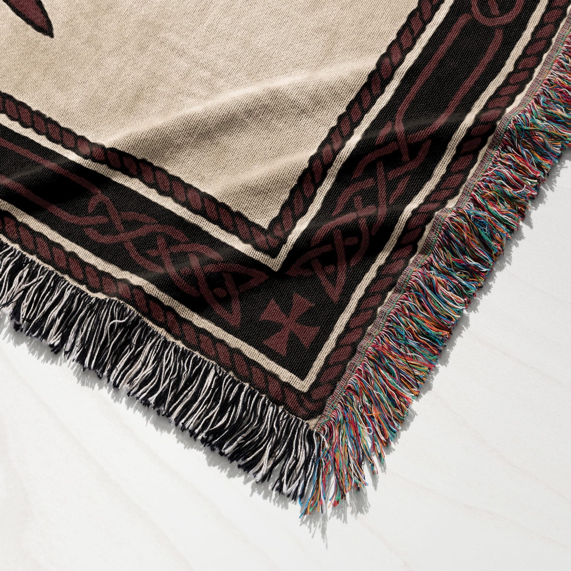 Woven blanket with Celtic knot border and tasseled edges.