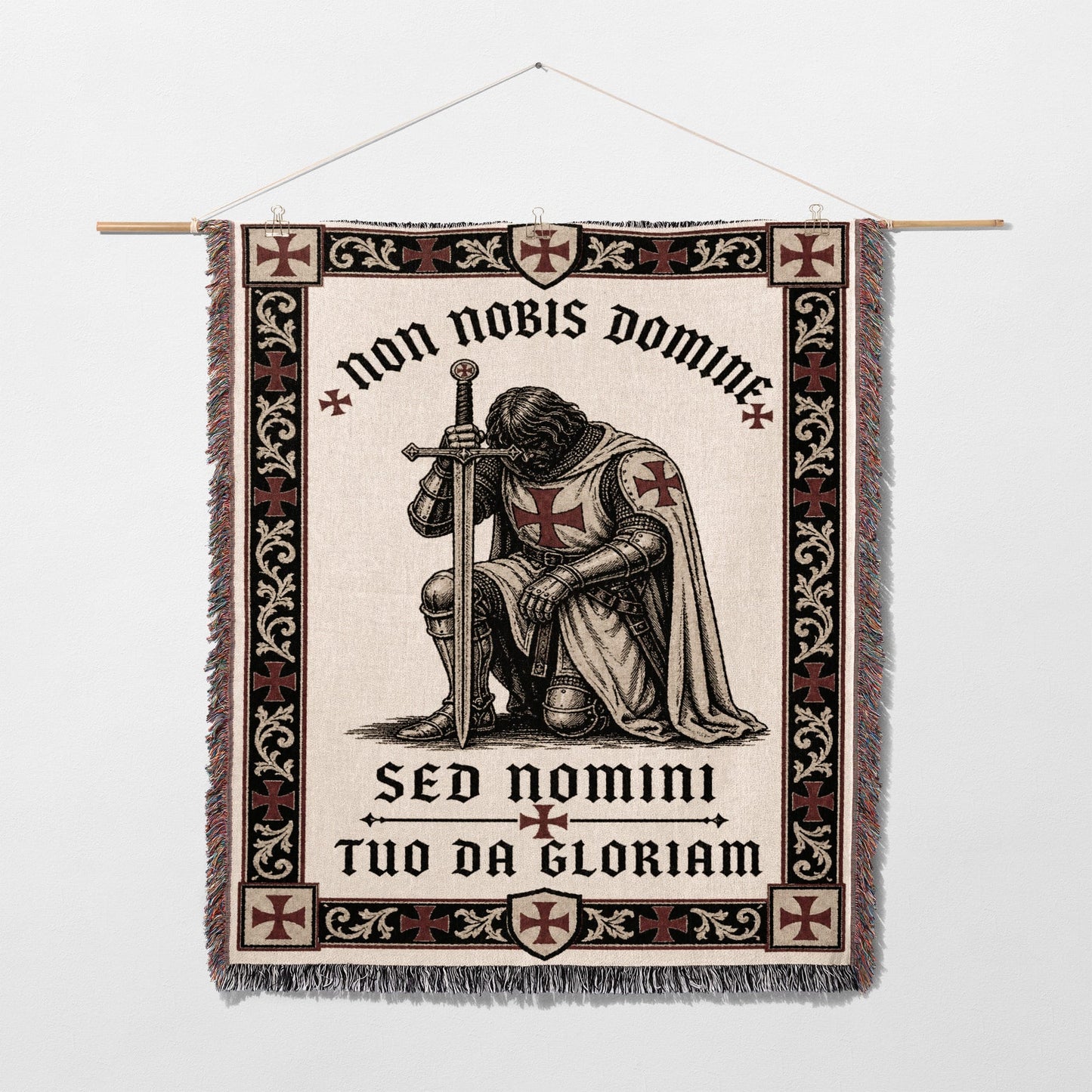 Tapestry of a kneeling knight in armor with Latin text.