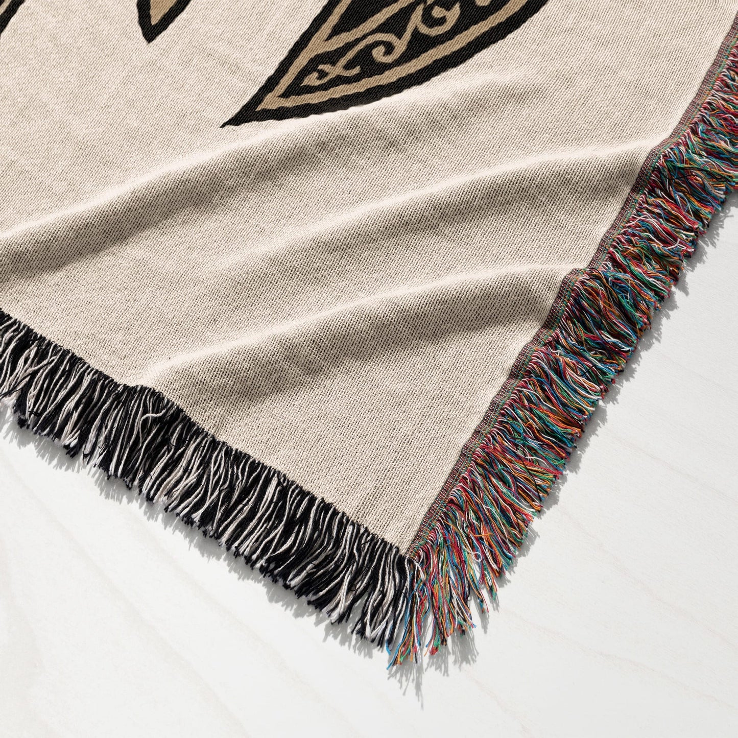 Woven blanket with fringed edges and black and gold Celtic knot pattern.