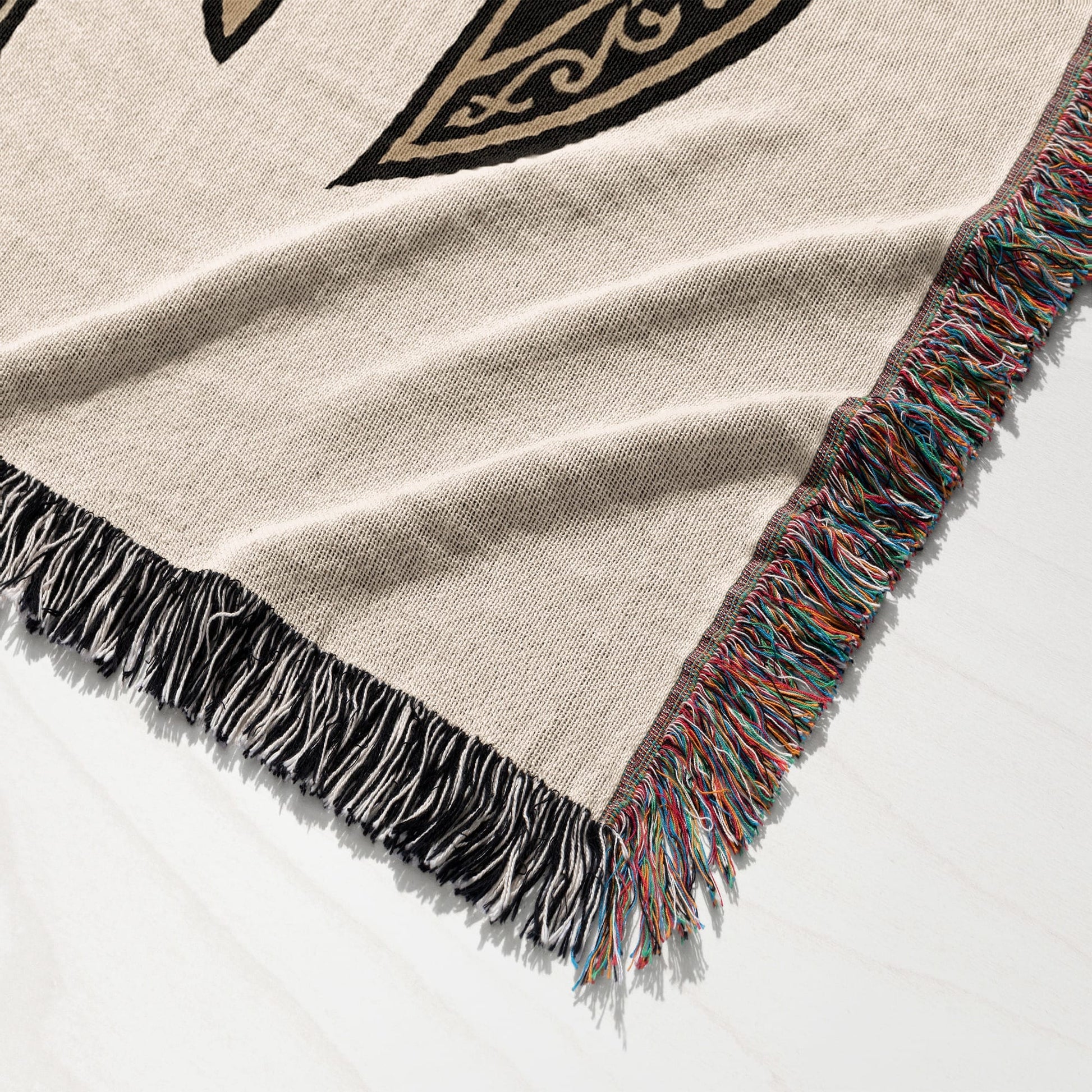 Woven blanket with fringed edges and black and gold Celtic knot pattern.