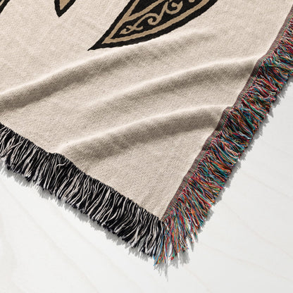 Woven blanket with fringed edges and black and gold Celtic knot pattern.