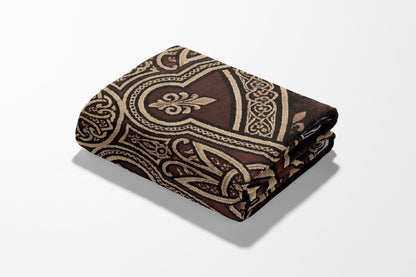 Folded fabric with ornate brown and beige geometric pattern.