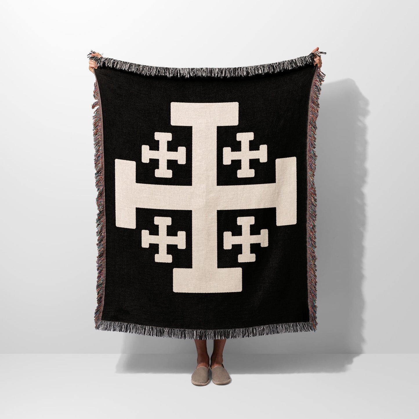 Black throw blanket with large beige Crusader cross and fringed edges.