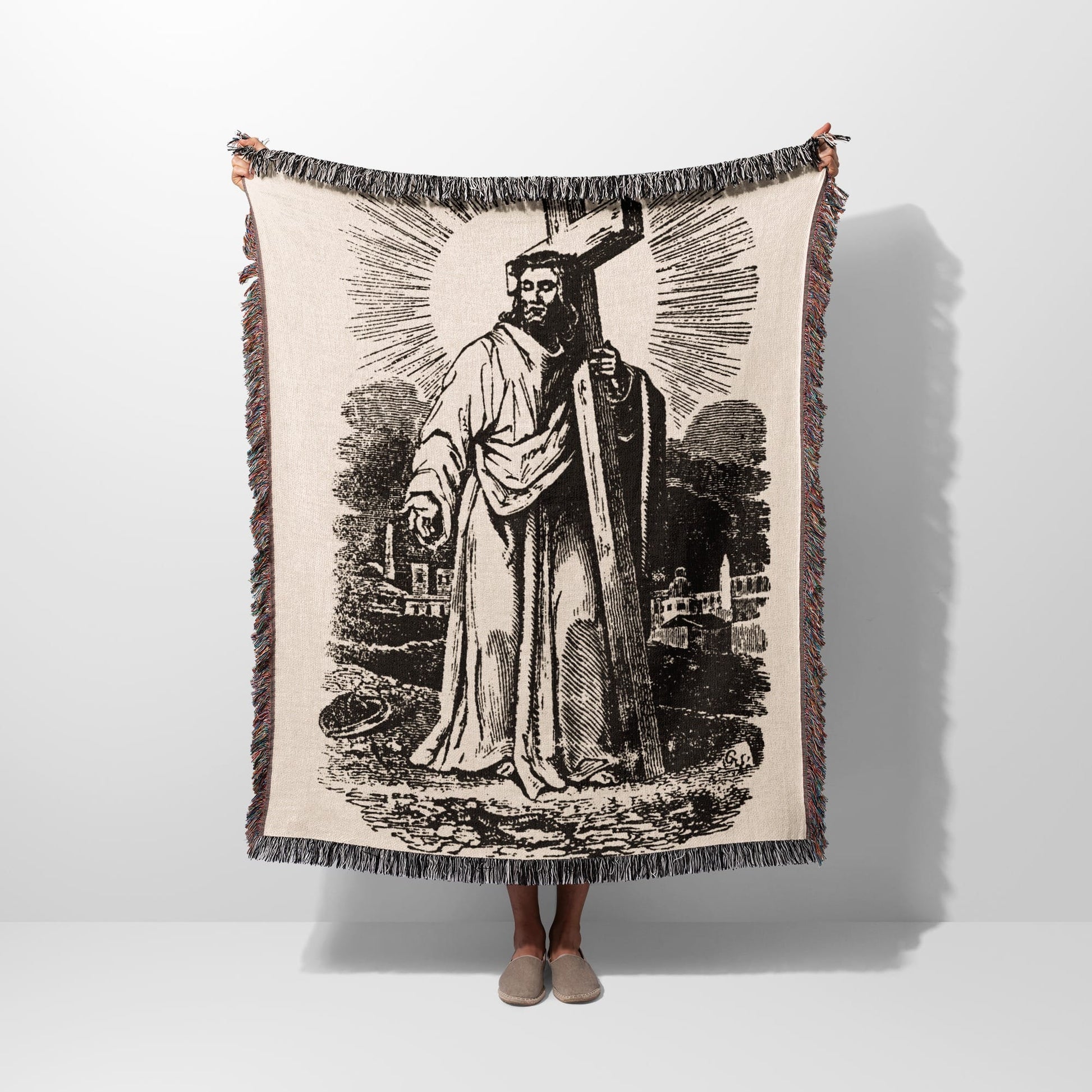 Jesus holding a cross, depicted in a vintage tapestry-style blanket.