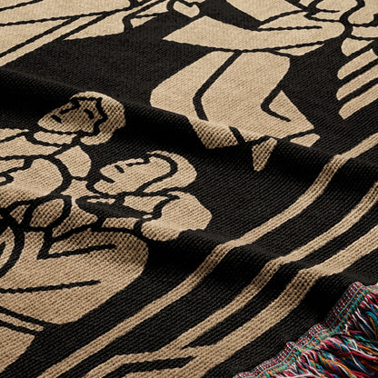 Black and tan woven blanket with floral design and fringed edge.