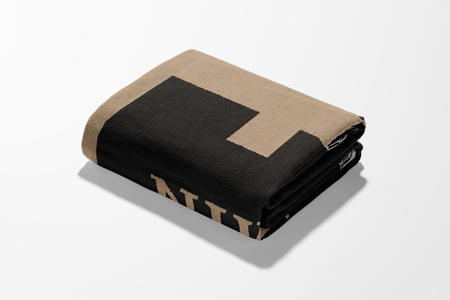 Tan and black folded blanket with "NATIONAL" text detail.