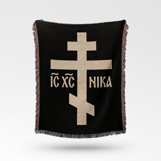 Black throw blanket with beige Eastern Orthodox cross and text.