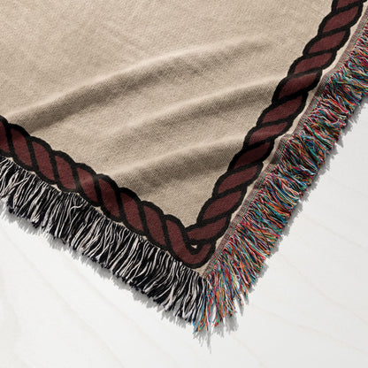 Tan woven throw blanket with braided trim and colorful fringe.