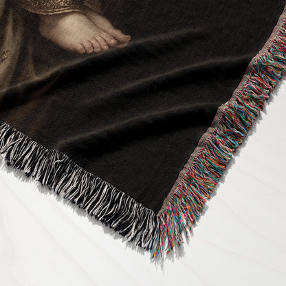 Woven blanket with a detailed fringe and a section of a painting showing a human foot.