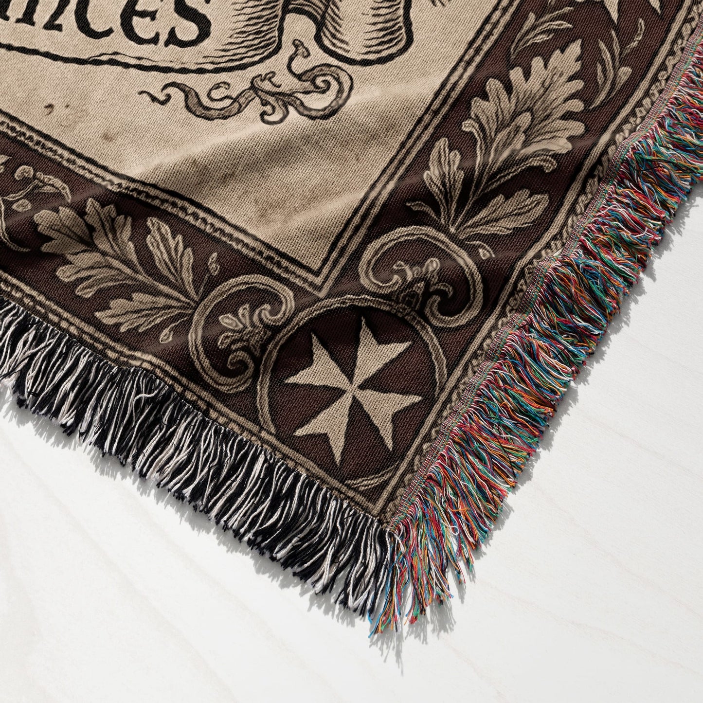 Tapestry throw with fringe, features scrollwork and a Maltese cross design.