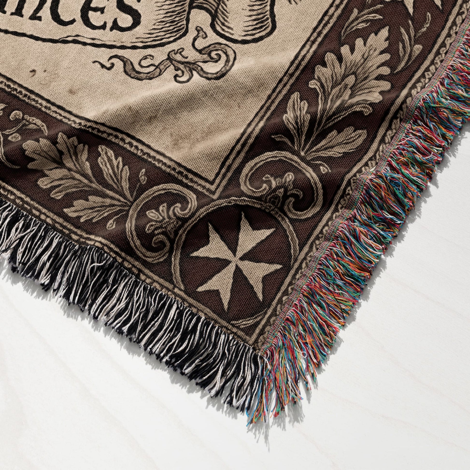 Tapestry throw with fringe, features scrollwork and a Maltese cross design.