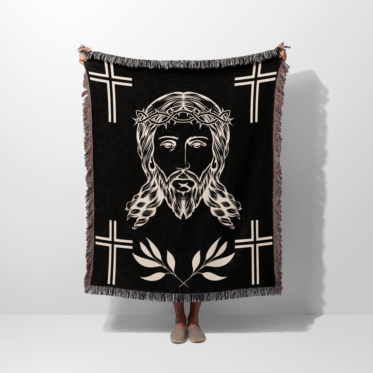 Black woven blanket with Jesus' face, crown of thorns, and crosses.