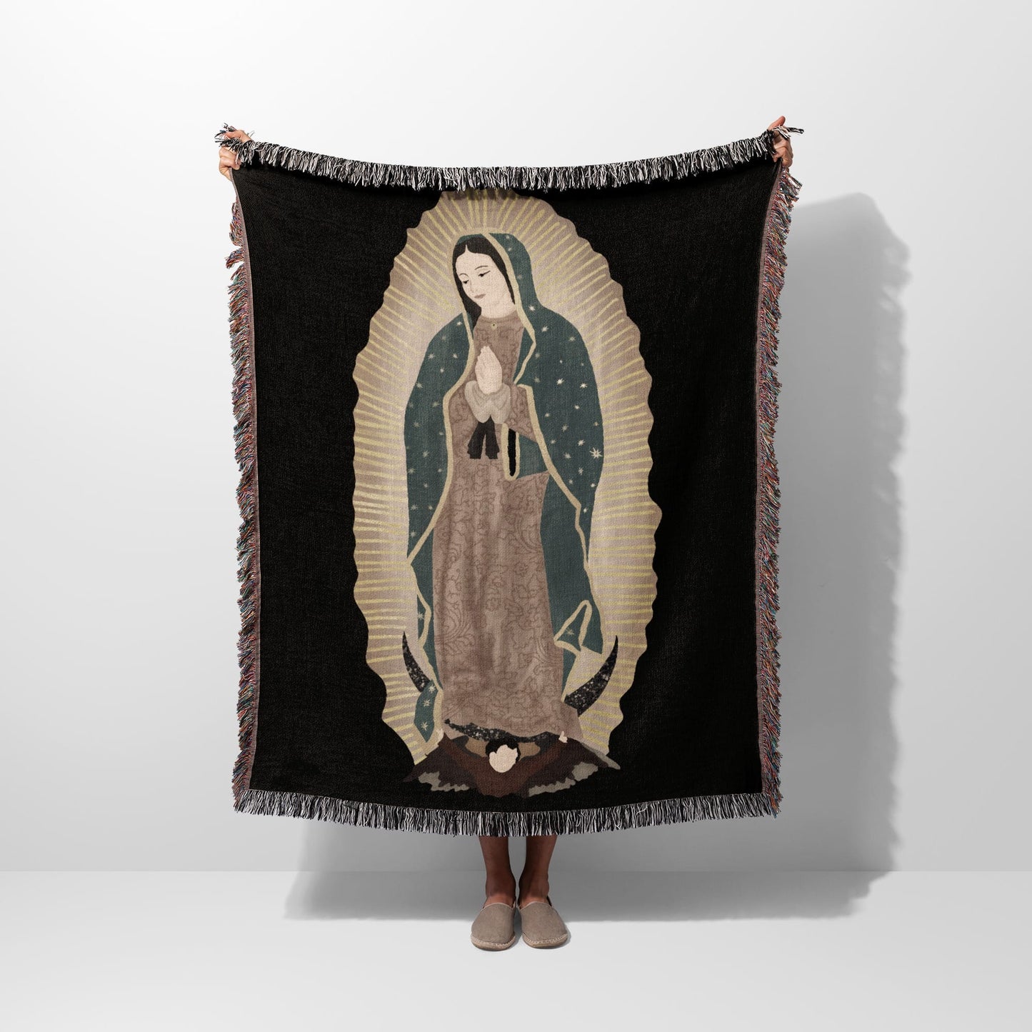 Woven blanket featuring an image of the Virgin of Guadalupe with fringed edges.