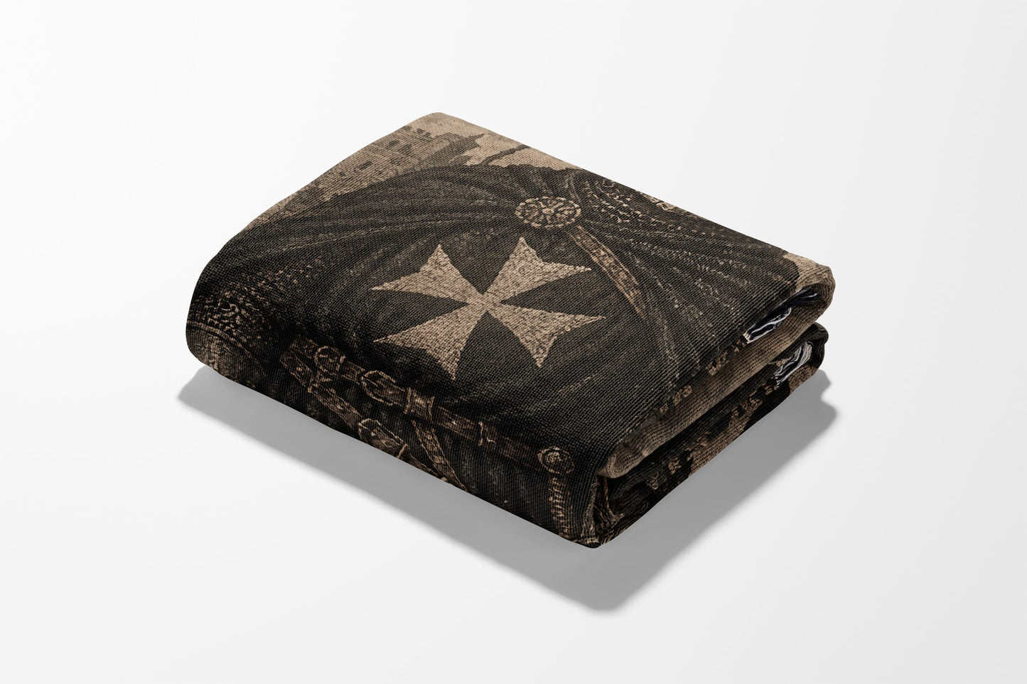 Folded blanket with a brown Maltese cross design and ornate trim.