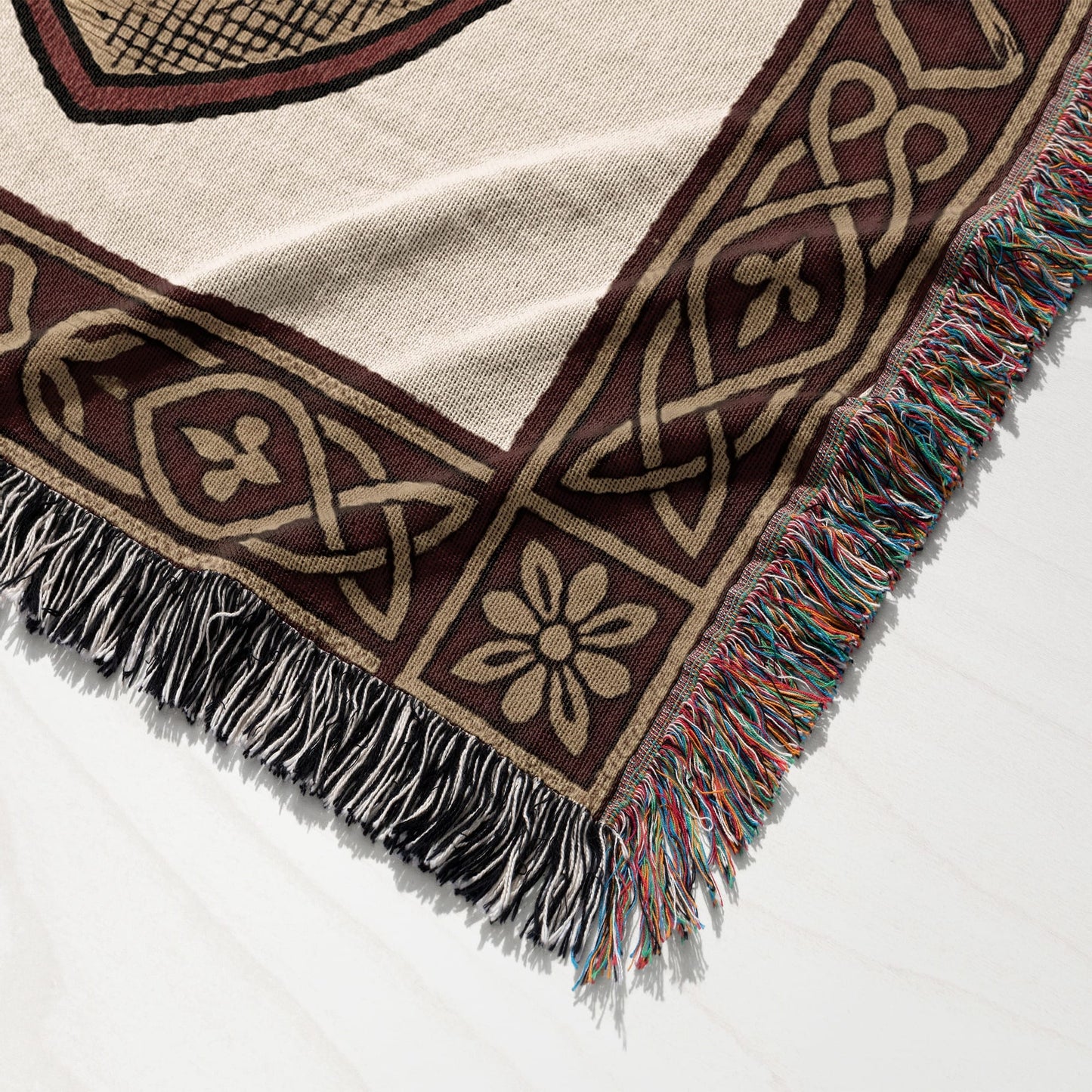 Woven throw blanket with Celtic knot pattern and fringed edges in multiple colors.