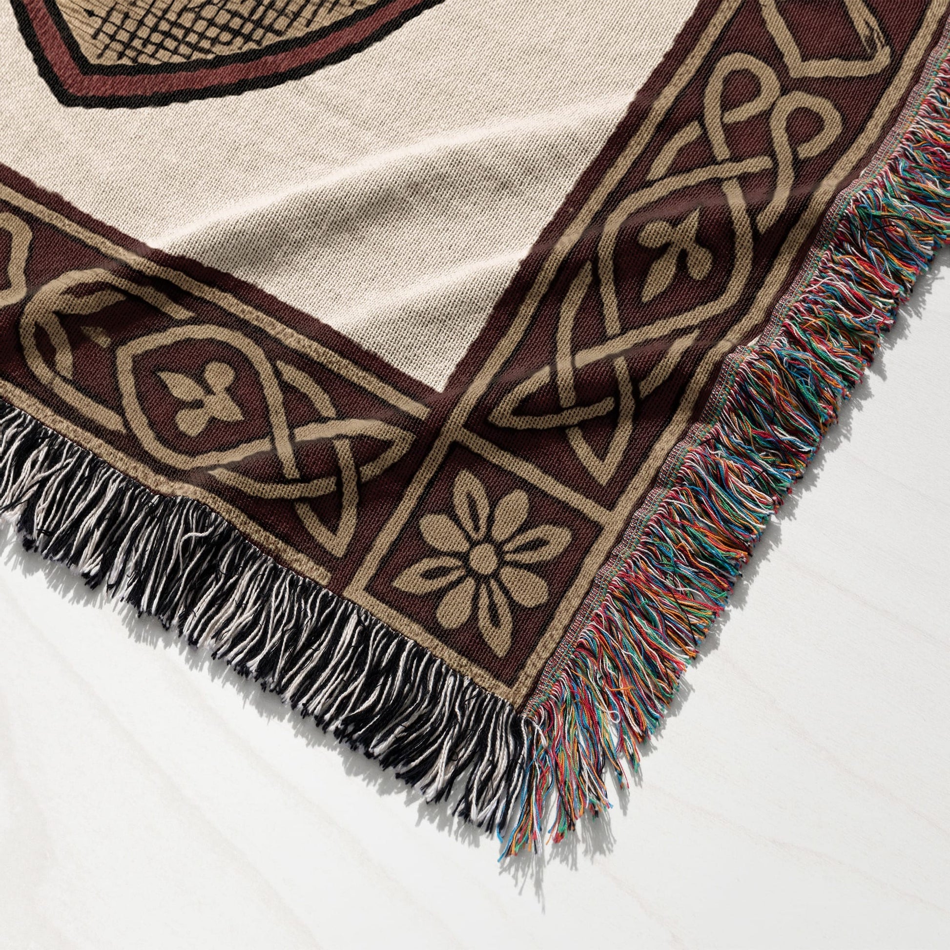 Woven throw blanket with Celtic knot pattern and fringed edges in multiple colors.