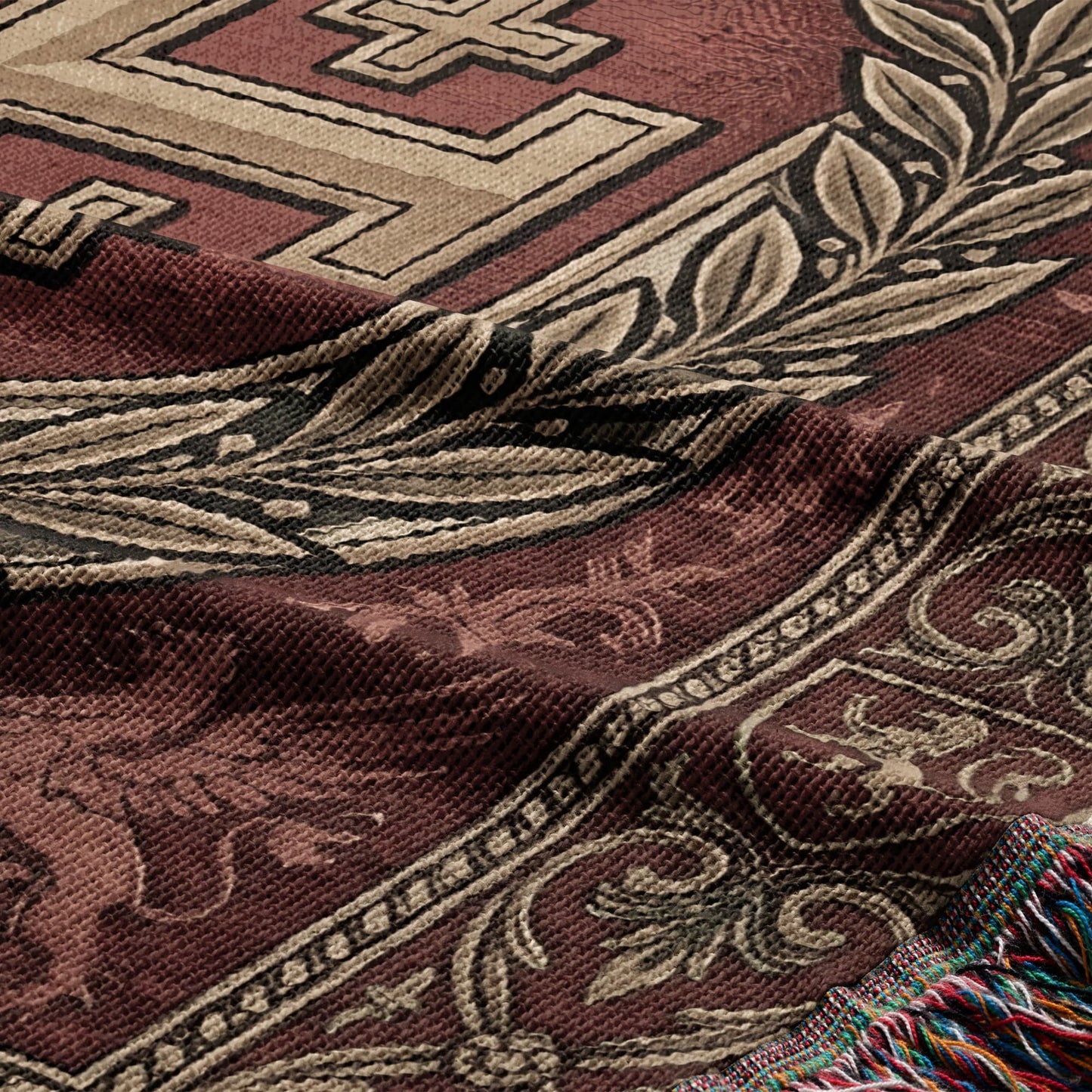 Tapestry throw with a burgundy background, geometric patterns, and fringe.