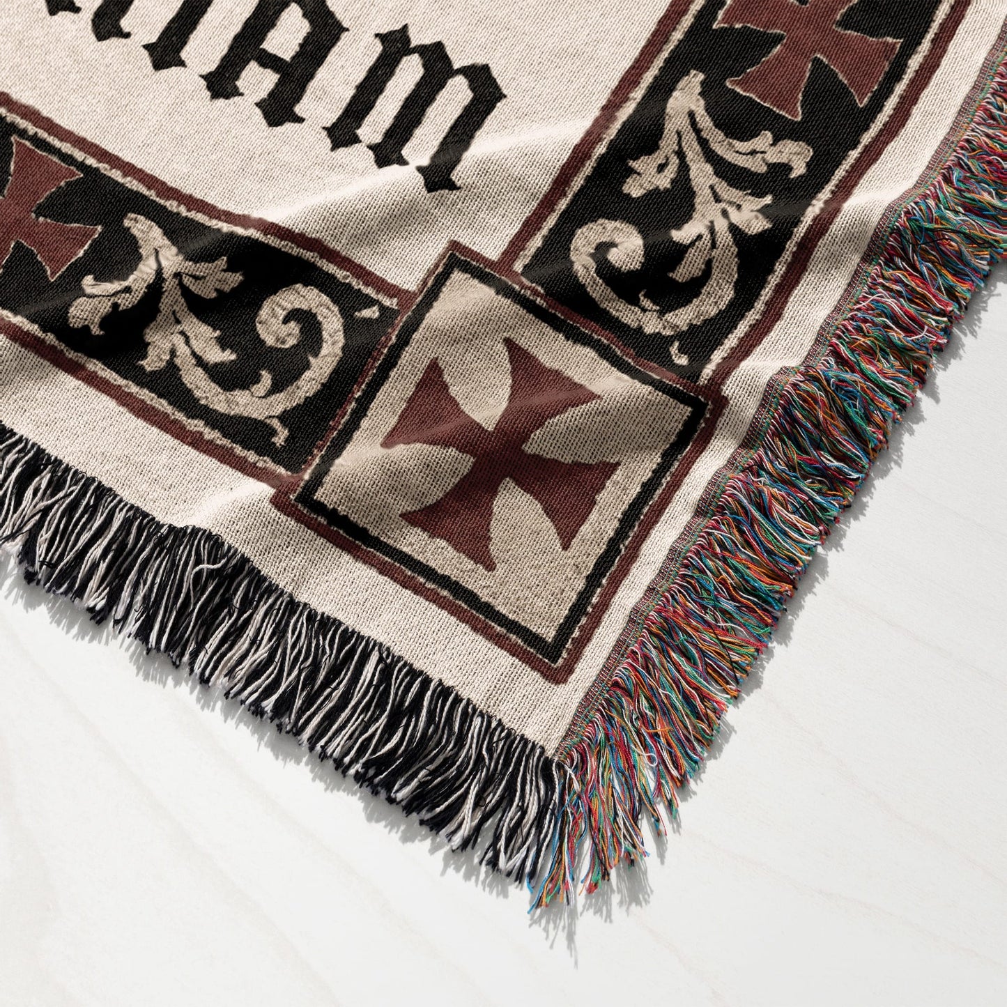 Knit blanket with cross pattern and fringed edges.