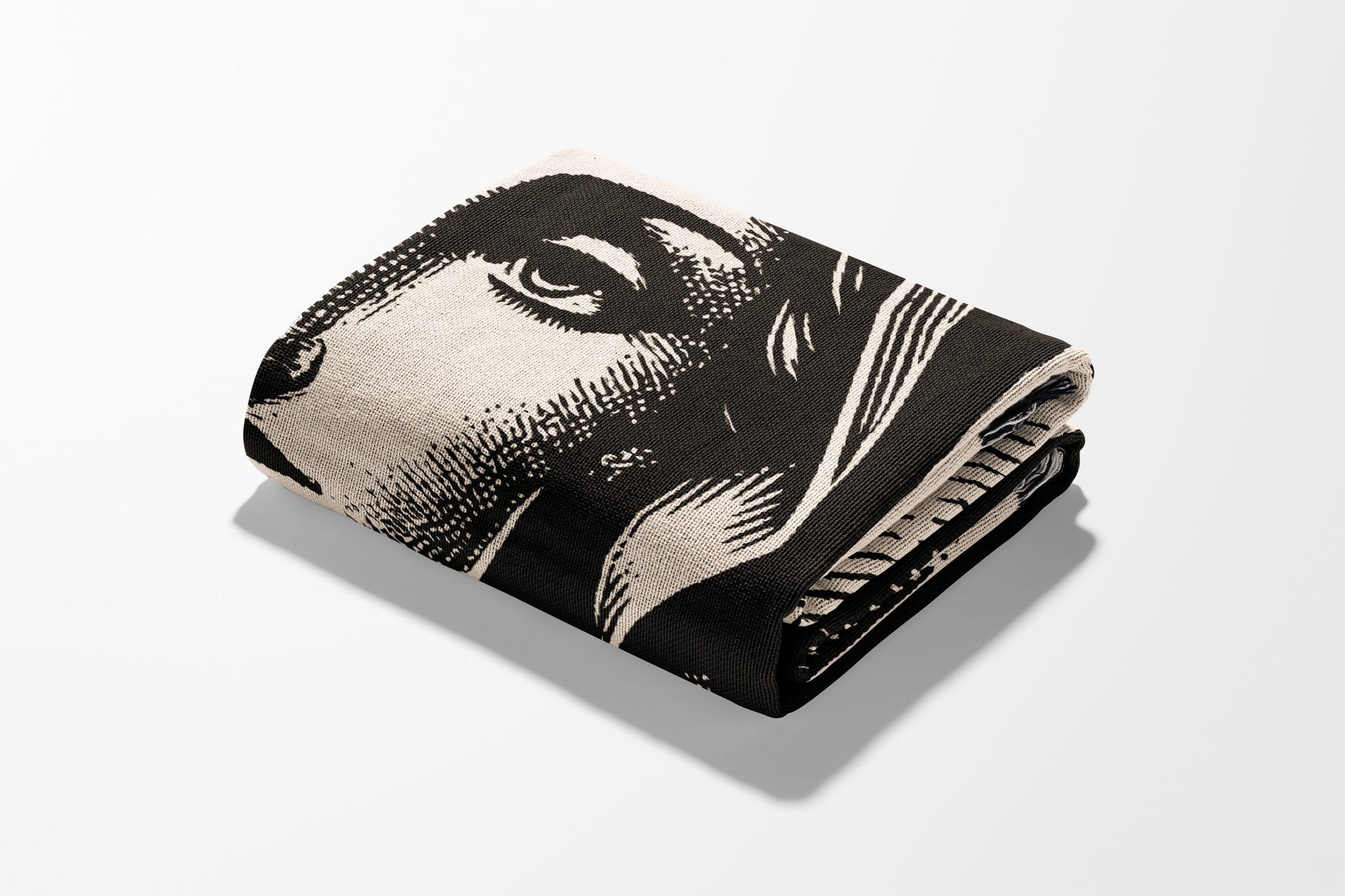 Folded blanket with black and white portrait of a person's face.