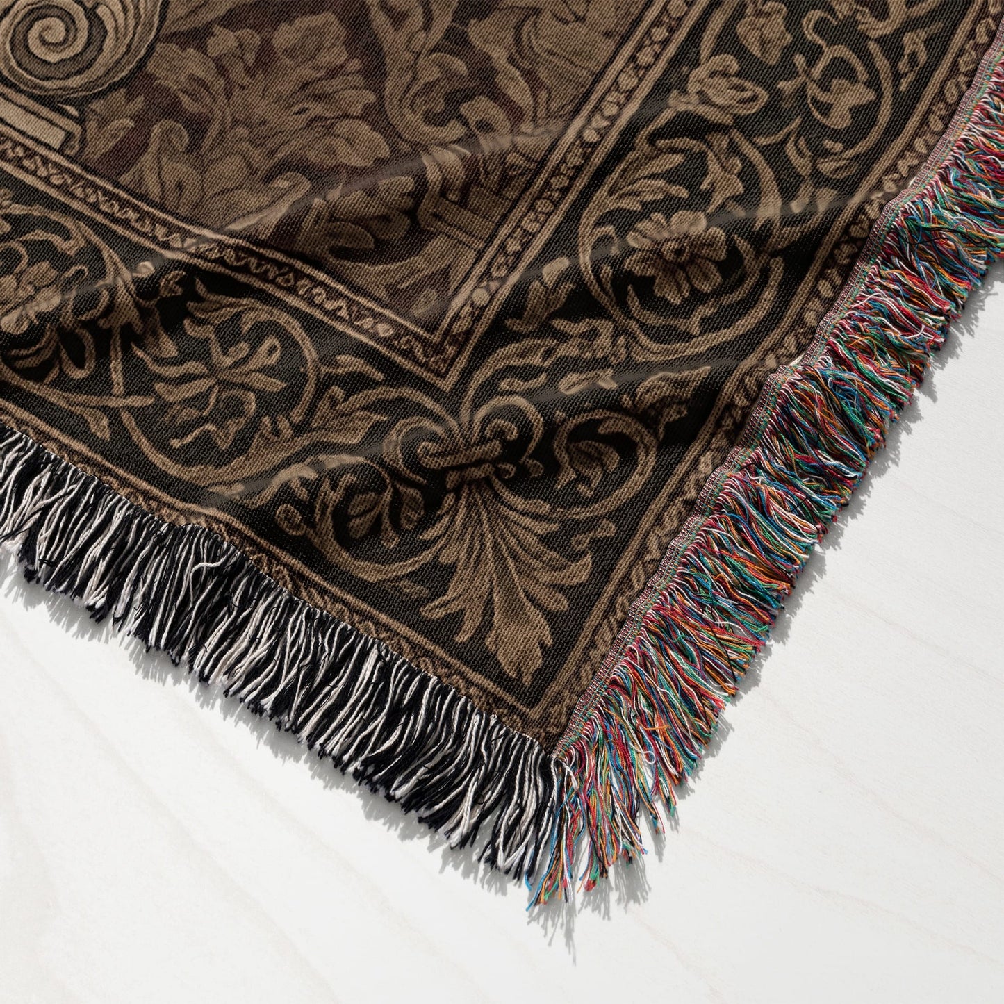 Brown and black patterned throw blanket with fringed edges and black, white, and multicolor tassels.