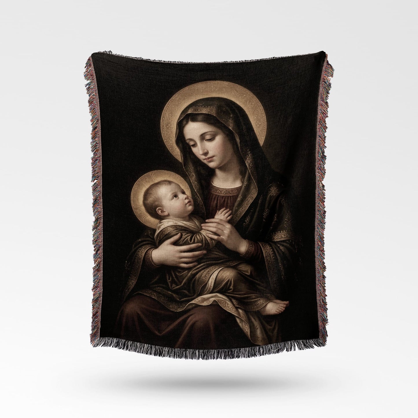 Religious artwork of the Madonna and Child displayed on a textured throw blanket.