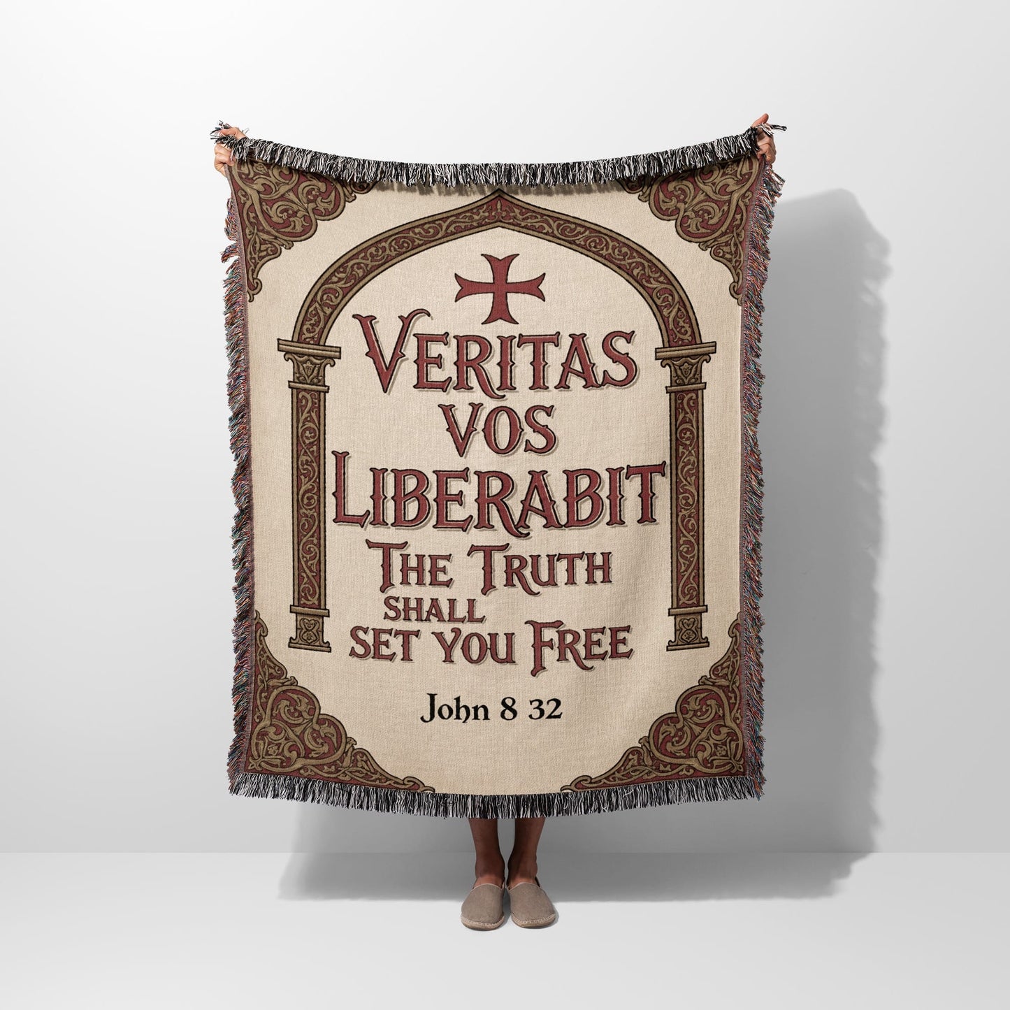 Tapestry with "Veritas Vos Liberabit" text and crosses, held by a person.