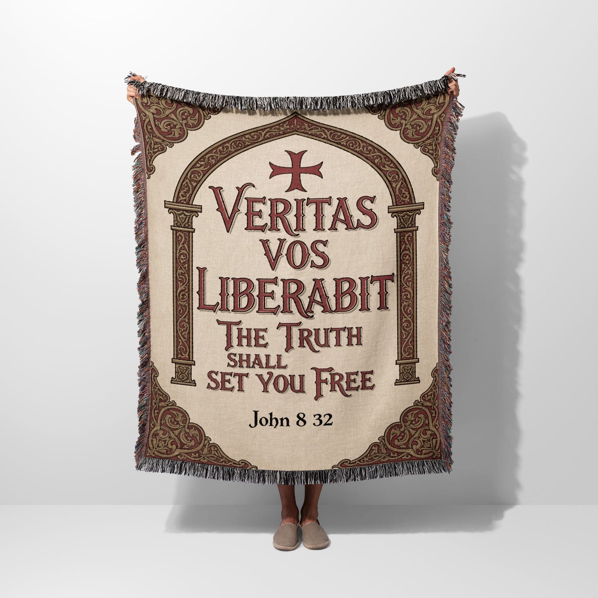 Tapestry with "Veritas Vos Liberabit" text and crosses, held by a person.