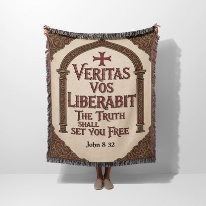 Tapestry with "Veritas Vos Liberabit" text and crosses, held by a person.