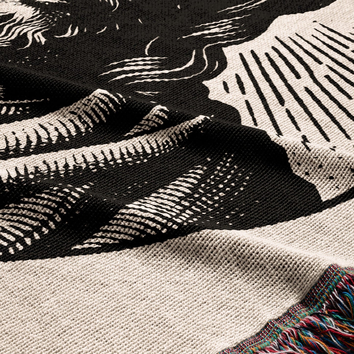 Black and white graphic blanket with colorful fringe.