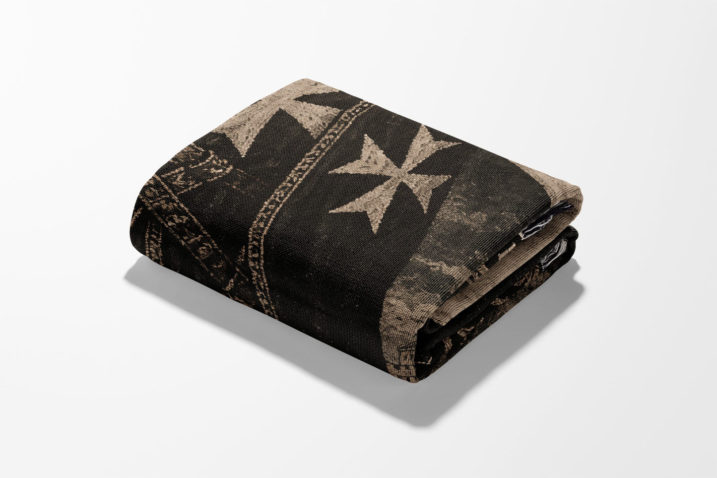 Folded dark brown blanket with a repeating white Maltese cross pattern.
